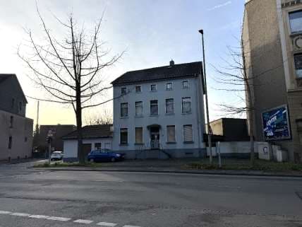 gemischt genutztes Gebäude mit Anbauten und Garagen bebaute Grundstück - Bild 1